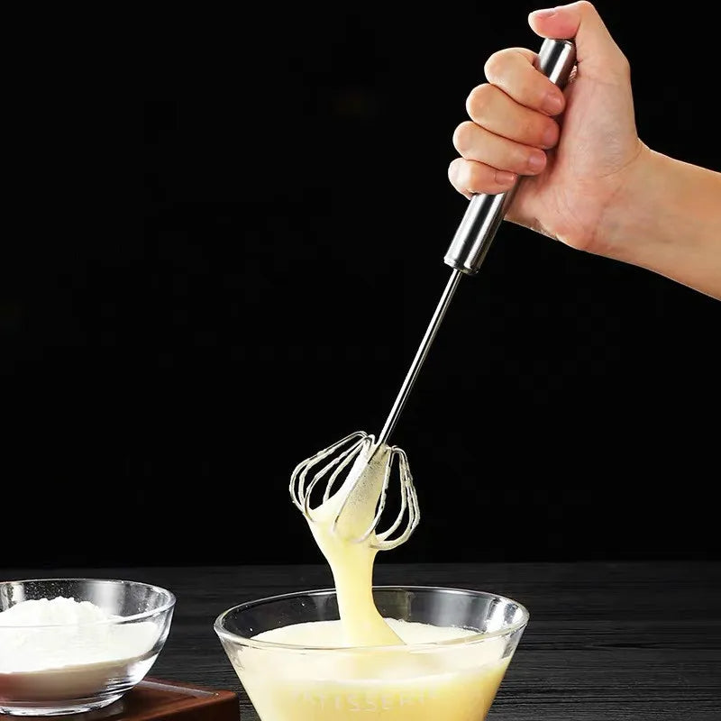 Stainless steel hand whisk alongside freshly mixed ingredients like eggs or cream, showcasing smooth final texture